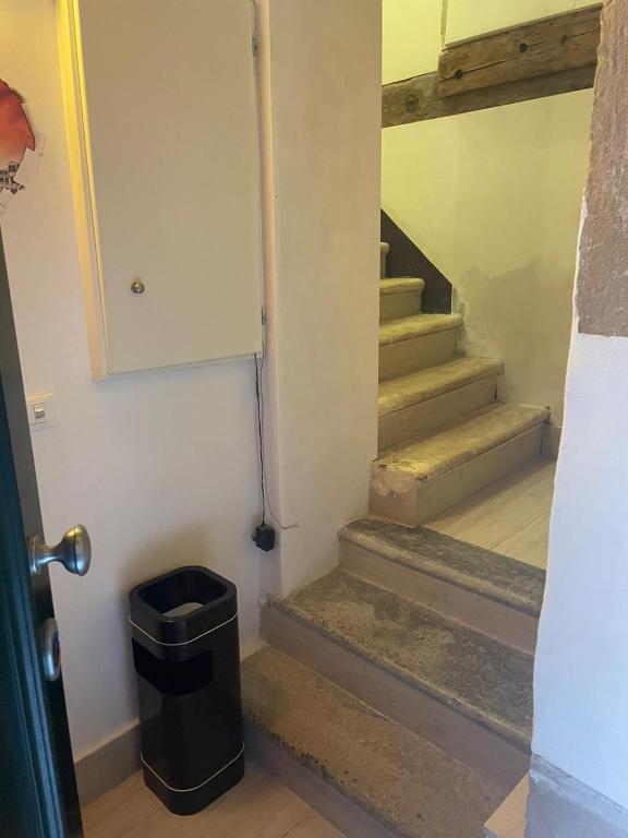 Un pasillo con escaleras con un bote de basura. en Dimora Blu Suite, en Venecia