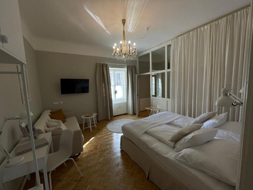 um quarto com uma cama grande e um lustre em White Flat by GrazRentals with cool location & free parking em Graz