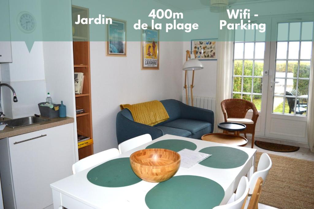 a kitchen and a living room with a table and chairs at Triplex avec jardinet - wifi - à 400m de la plage in Courseulles-sur-Mer