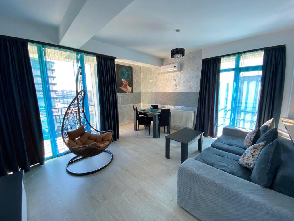 a living room with a blue couch and a chair at Apartament Ella T2 in Mamaia Sat/Năvodari