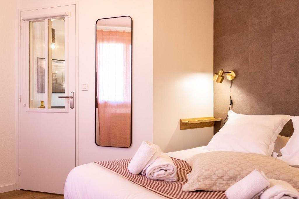 une chambre avec un lit avec un miroir au mur dans l'établissement Les Écureuils - calme, parking & balcon, à Annecy