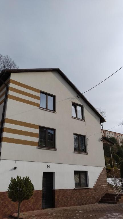 ein weißes Gebäude mit braunen und weißen Streifen darauf in der Unterkunft BiesCZADOWE miejsce in Lesko