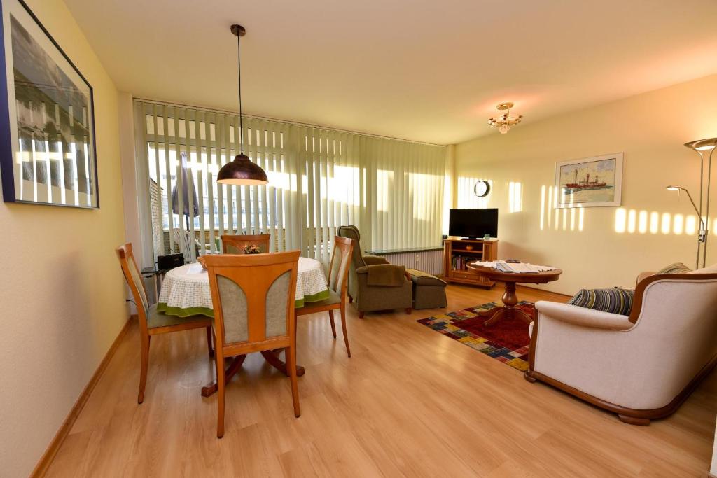 a living room with a table and chairs at Haus "Panorama" Appartement PAN049 in Duhnen