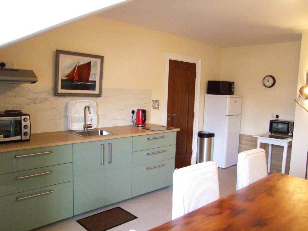 uma cozinha com um lavatório, uma mesa e um frigorífico em Glendalough 10 Minutes from Beautiful Farmhouse em Roundwood