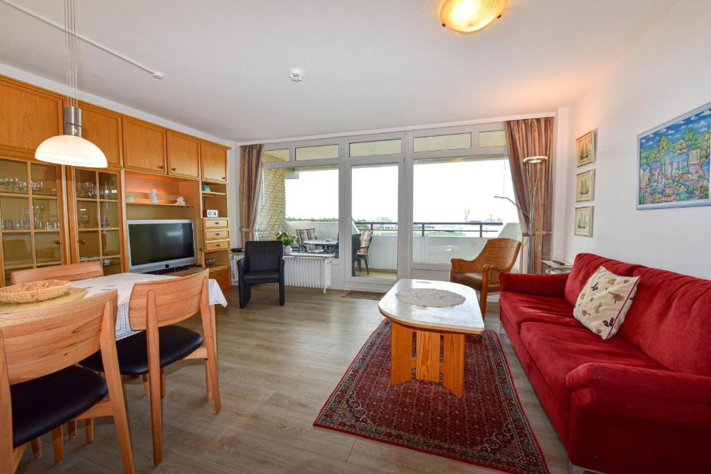 a living room with a red couch and a table at Haus "Panorama" Appartement PAN096 in Duhnen