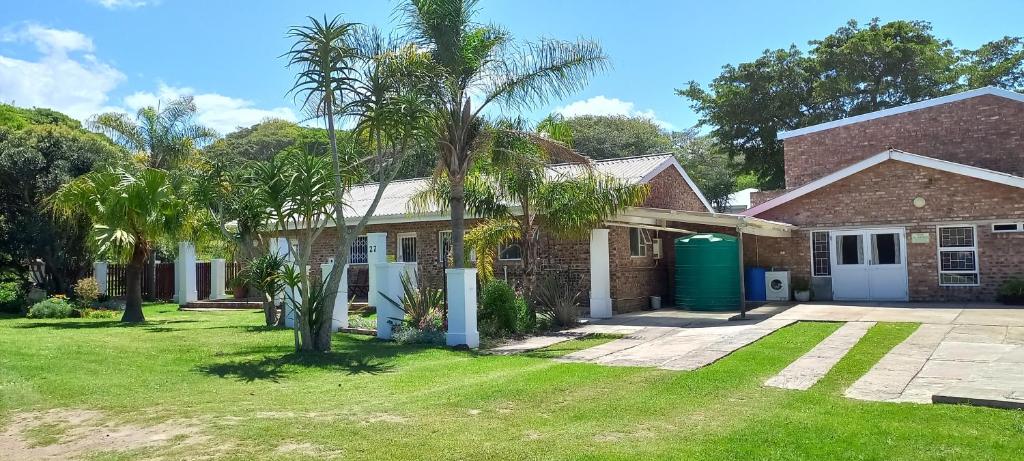 a house with a palm tree in the yard at Dollery House in Port Alfred