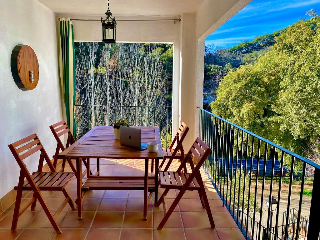 einen Tisch mit Stühlen und einen Laptop auf dem Balkon in der Unterkunft Casa Rural La Senda de Aroche in Aracena