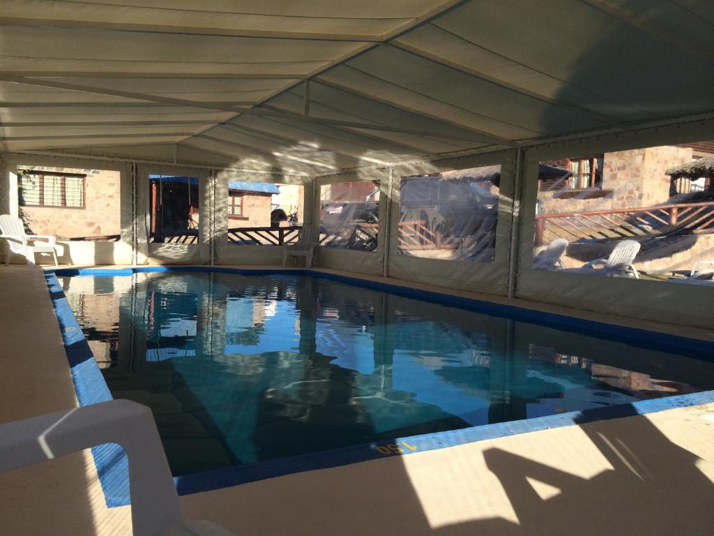 einen Pool unter einem Zelt mit blauem Wasser in der Unterkunft Cabañas El Madero in Villa Carlos Paz
