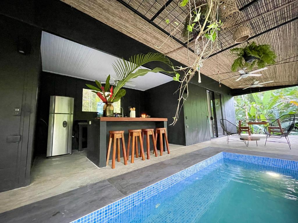 a kitchen and a swimming pool in a villa at Villa JOEYSHE- New Luxury Villa with Pool & AC in Puerto Viejo