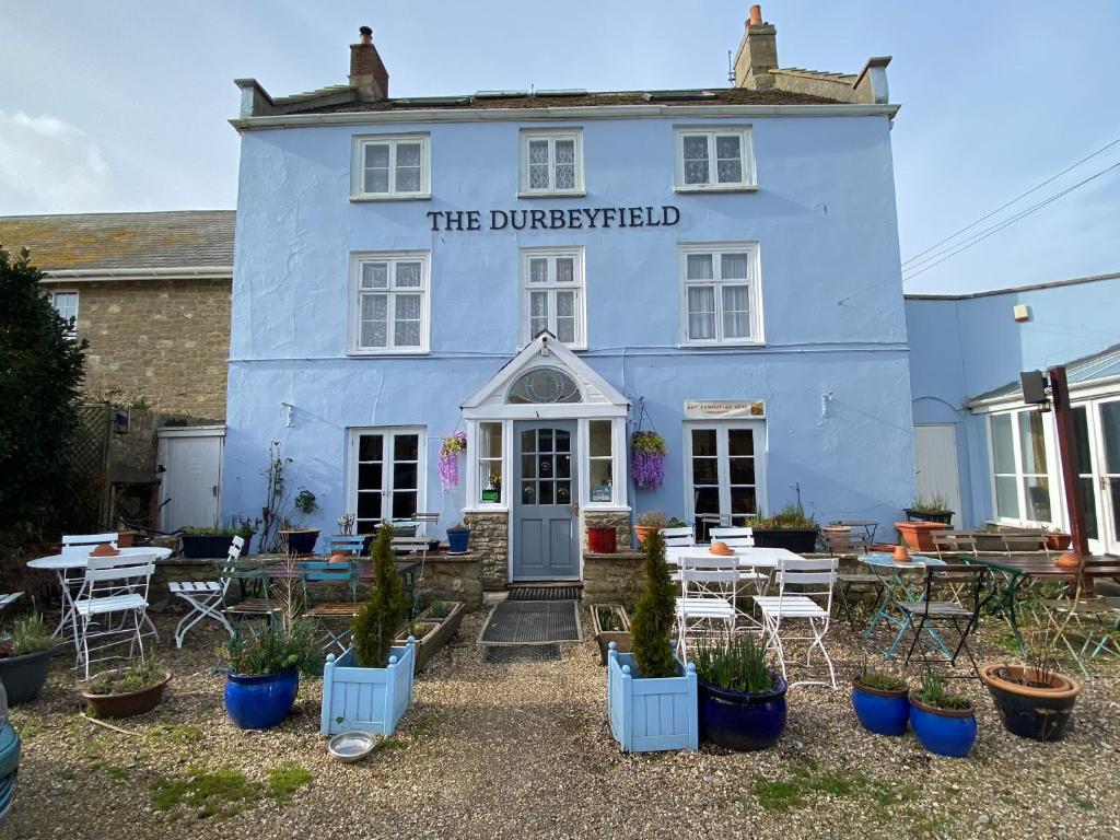 um edifício azul com plantas em frente em The Durbeyfield Guest House em West Bay