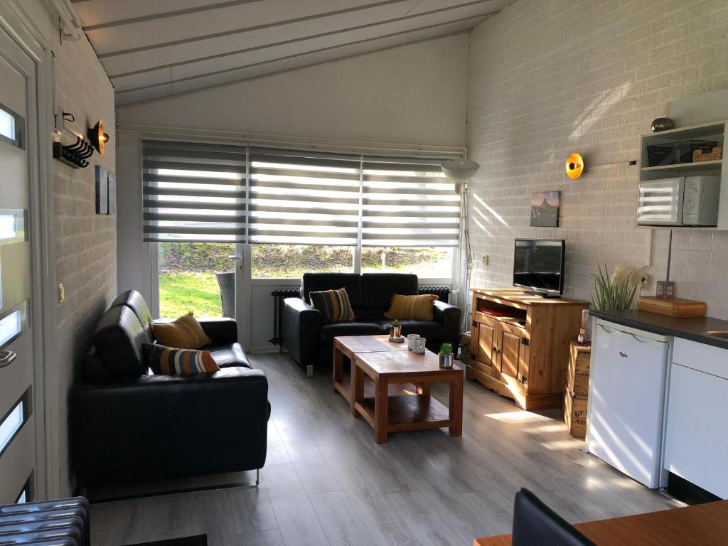 ein Wohnzimmer mit 2 Sofas und einem Tisch in der Unterkunft Vakantiebungalow nr 7 in het Heuvelland in Simpelveld