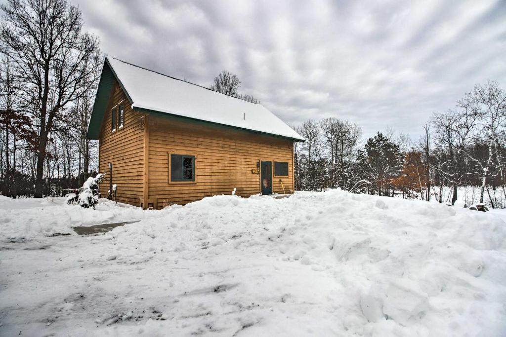 een houten hut met een berg sneeuw ervoor bij Cabin with Fireplace Less Than 1 Mile to Lakes and Golf in Pequot Lakes