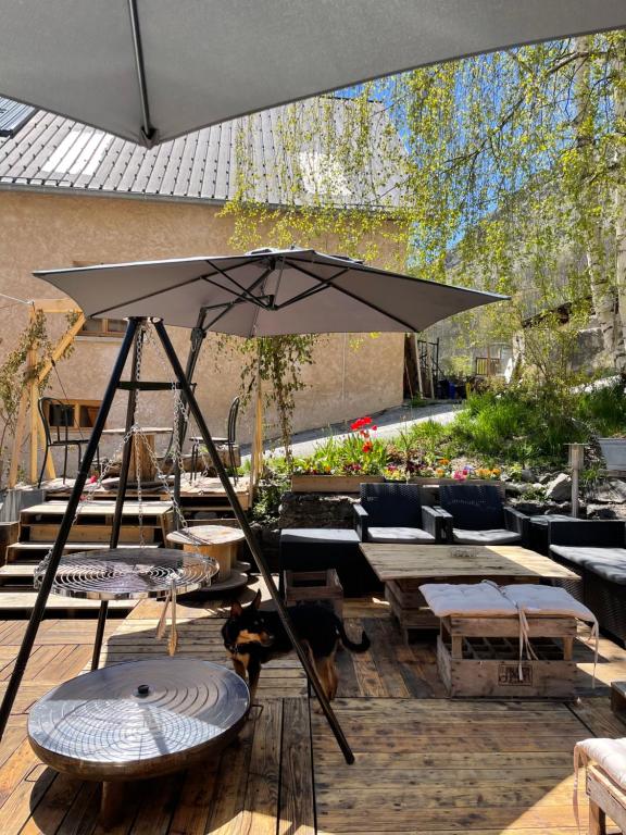 a patio with an umbrella on a wooden deck at Auberge du Savel in Clavans-en-Haut-Oisans