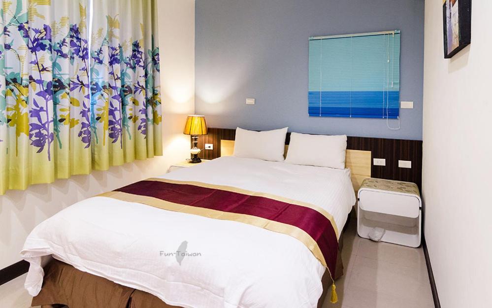 a bedroom with a large bed and a window at Tainan Yi Zhan in San-fen-tzu