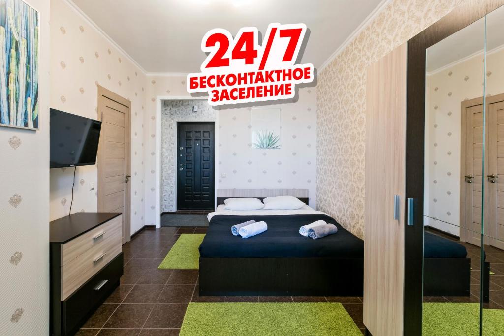 PutilkovoにあるMaxRealty24 UP-kvartal 2のベッドルーム1室(ベッド1台付)とパラシュートを読むサイン