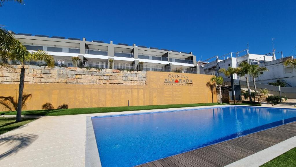 a swimming pool in front of a building at Alvorada Premium by Sunny Deluxe in Albufeira