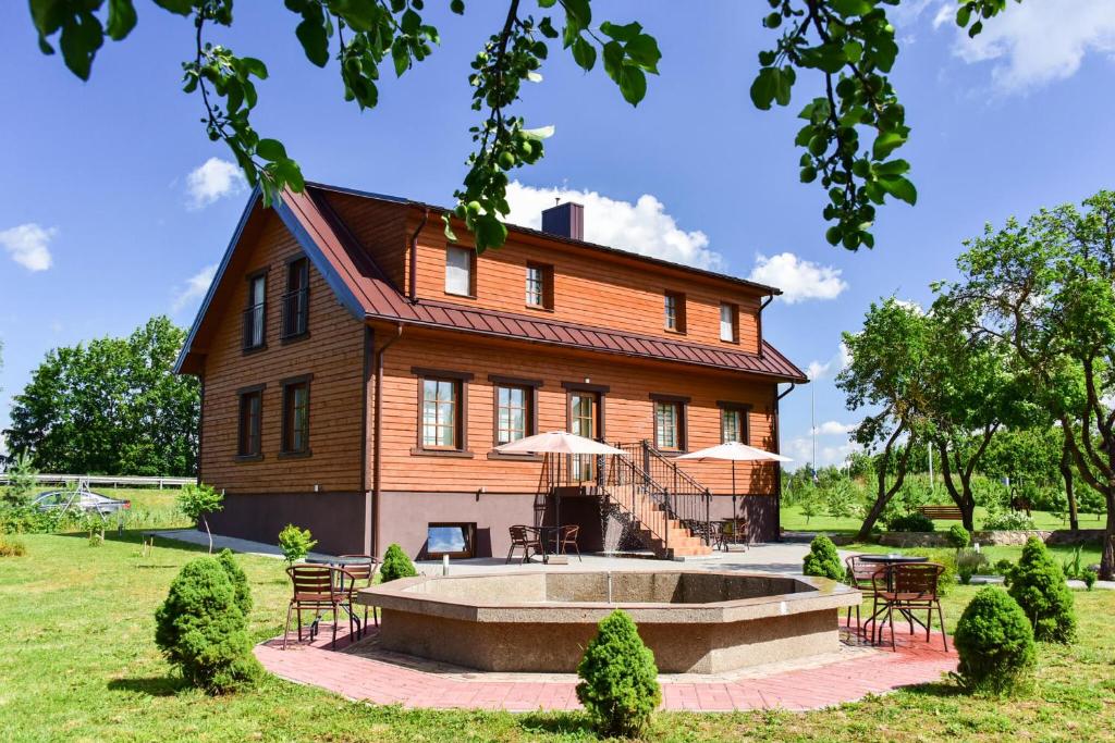 una casa con una fuente frente a ella en "Trakaitis" Entire Deluxe Villa, en Trakai