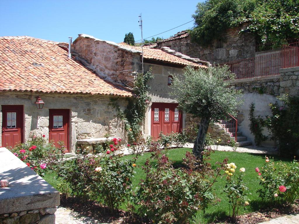 a house with red doors and a yard with flowers at Casa Real Danaia in Germil