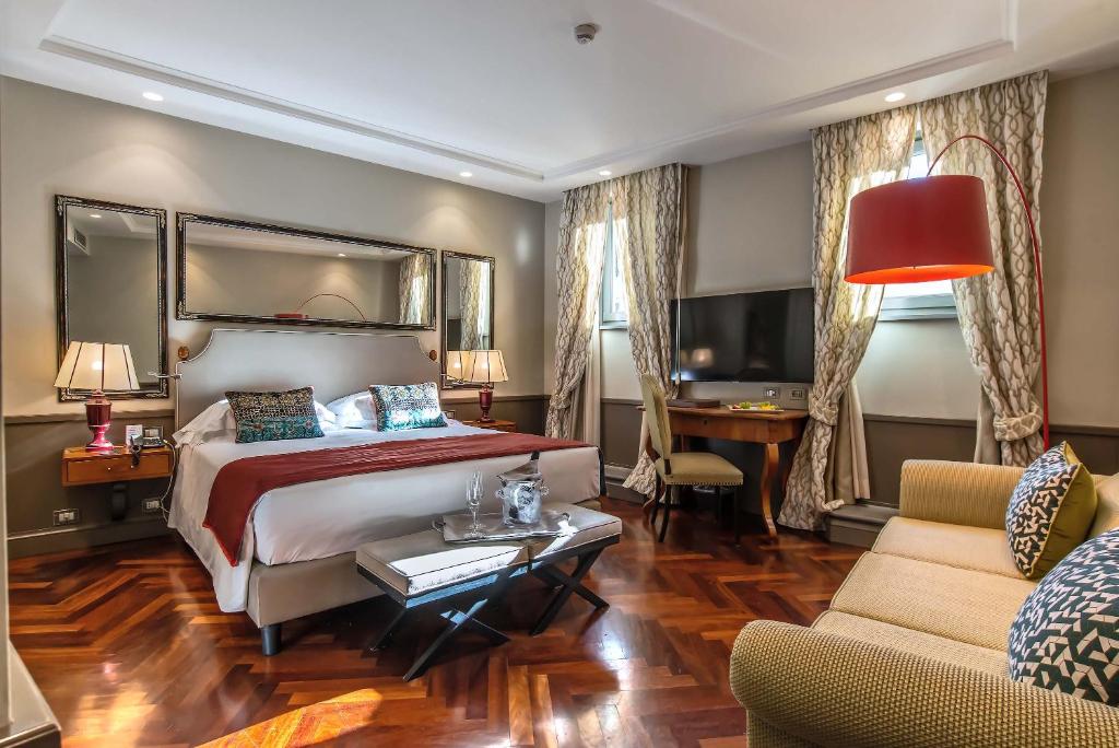 ローマにあるホテル ルネッタのベッドとデスクが備わるホテルルームです。