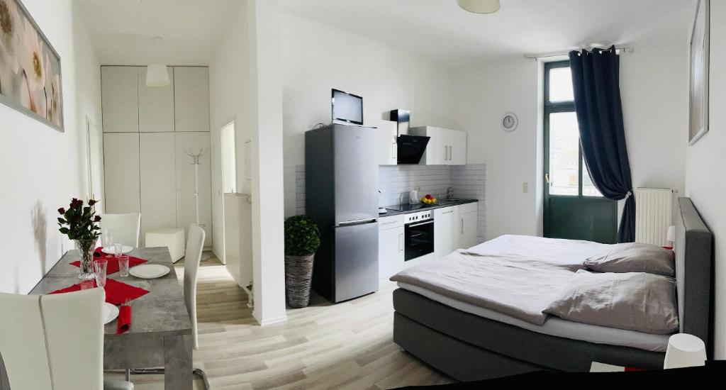 une chambre avec un lit et une cuisine avec une table dans l'établissement Downtown Apartment 4U Leipzig, à Leipzig