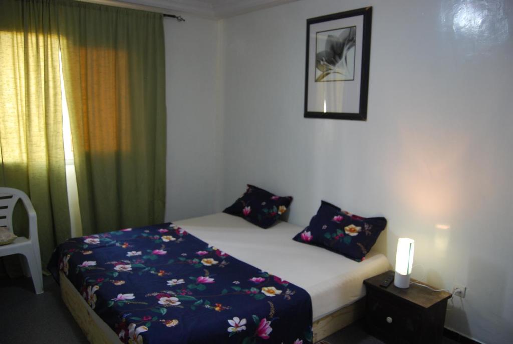 Un dormitorio con una cama con una manta azul. en Dakar Top destination, en Dakar