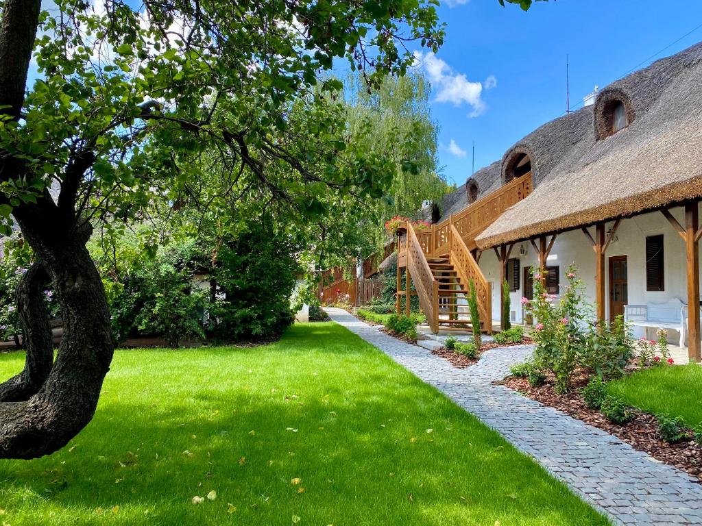 een huis met een grasveld en een trap bij The Houses of History - anno 1830 in Tihany