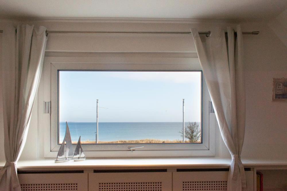 una ventana en una habitación con vistas al océano en Ferienwohnung Lachmöwe, en Scharbeutz