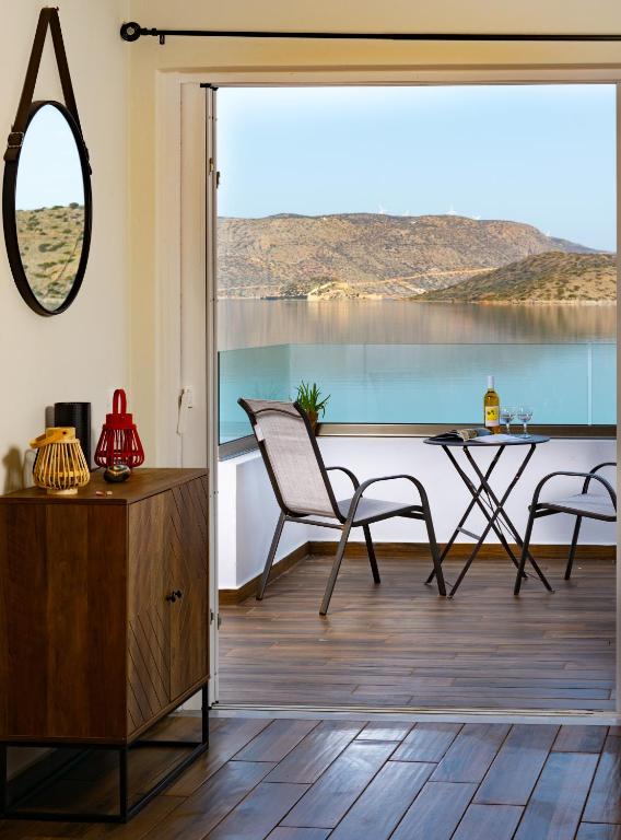 a living room with a table and chairs and a window at Elounda Harmony Sea front apartment in Elounda
