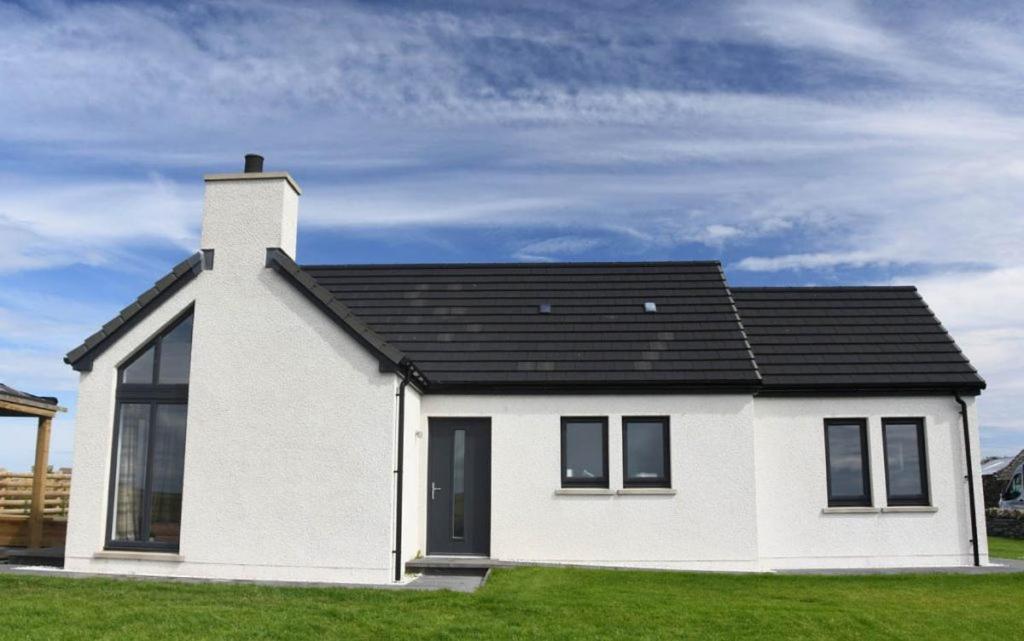 a white house with a black roof at Taylor's Rest in Toab