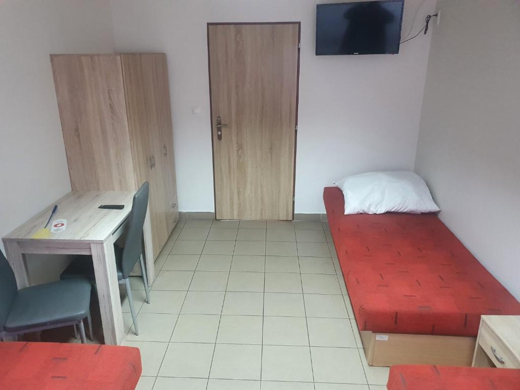 Pokój z czerwonym łóżkiem, biurkiem i telewizorem w obiekcie ubytovanie FRENAT w mieście Kúty