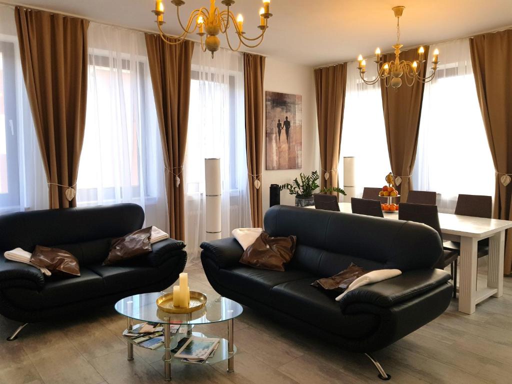 salon z dwoma czarnymi kanapami i stołem w obiekcie Apartment Deluxe, inklusive WLAN, Parkplatz und Netflix w mieście Schleiden