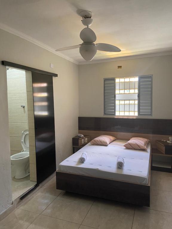 1 dormitorio con 1 cama y baño con aseo en Hotel Ouro de Mauá, en Mauá