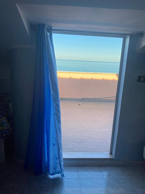 ein Fenster mit einem blauen Vorhang in einem Zimmer in der Unterkunft Casa vacanze costa dei Trabocchi in Fossacesia