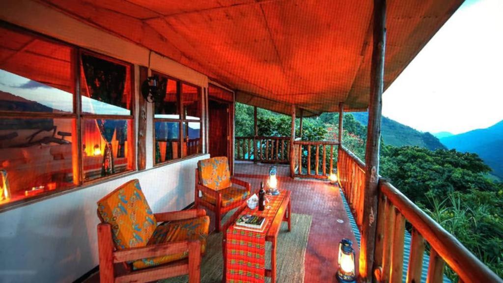 Kisoro的住宿－Gorilla Closeup Lodge，阳台,配有椅子和桌子