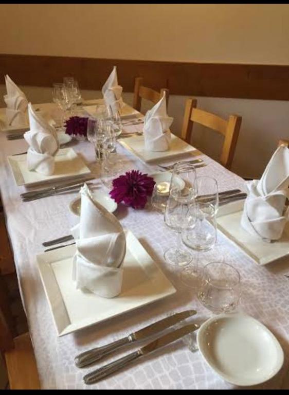a table with a white table cloth with glasses and napkins at Auberge du Savel in Clavans-en-Haut-Oisans