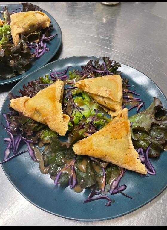 a blue plate of food with pita sandwiches and a salad at Auberge du Savel in Clavans-en-Haut-Oisans