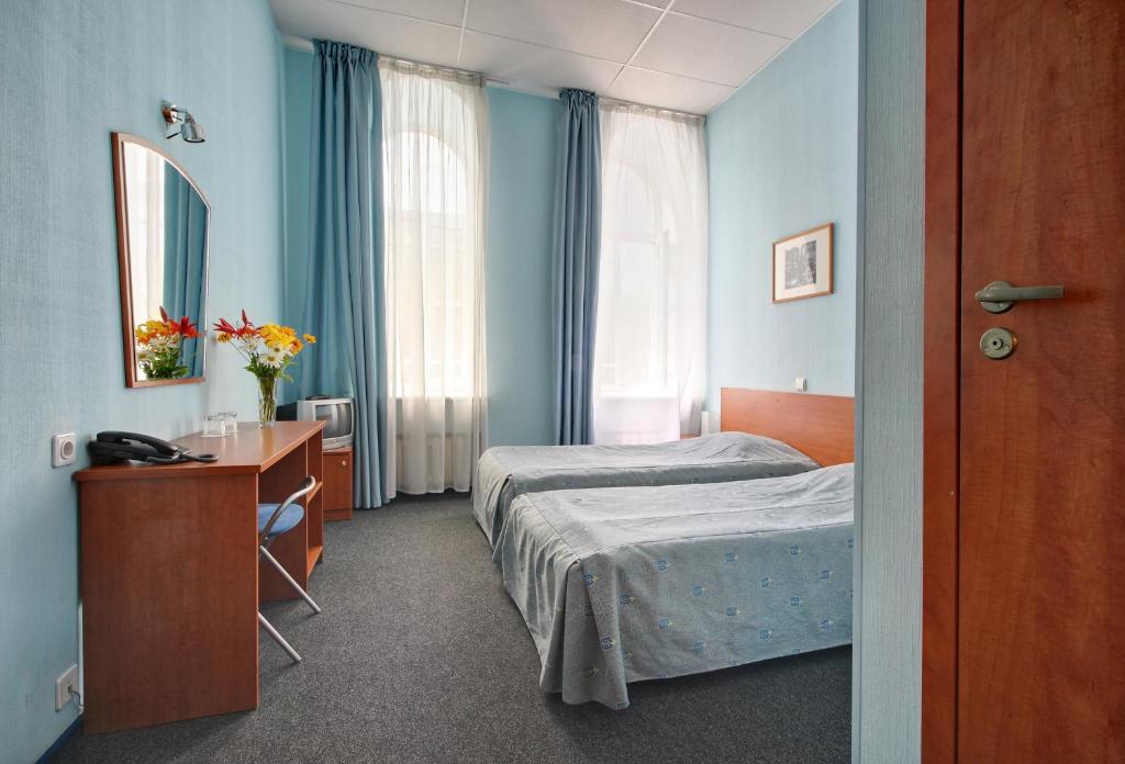 - une chambre avec 2 lits, un bureau et un miroir dans l'établissement Rinaldi at Moscovsky Prospekt 18, à Saint-Pétersbourg