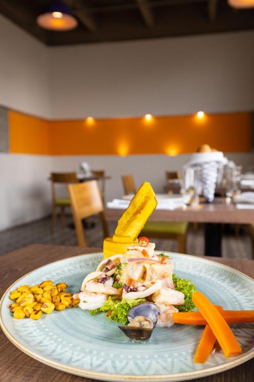 a plate of food with vegetables on a table at Hotel Bari Bucaramanga in Bucaramanga