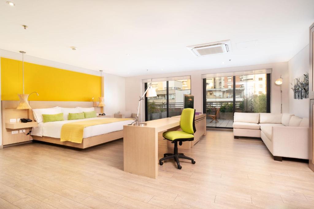 a bedroom with a bed and a desk and a chair at Hotel Bari Bucaramanga in Bucaramanga