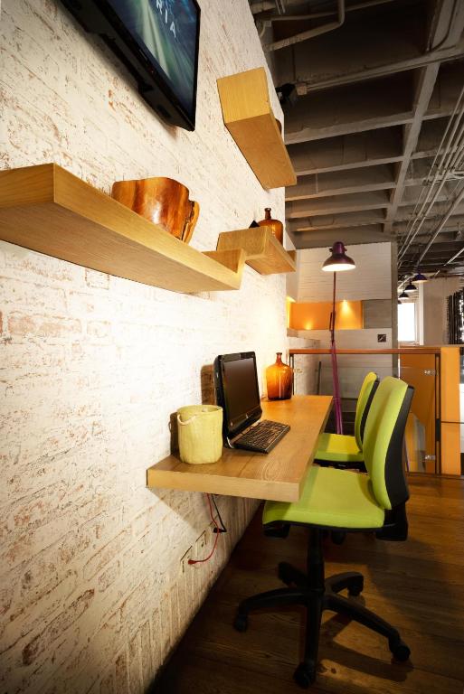an office with a desk with a laptop and a green chair at Hotel Bari Bucaramanga in Bucaramanga