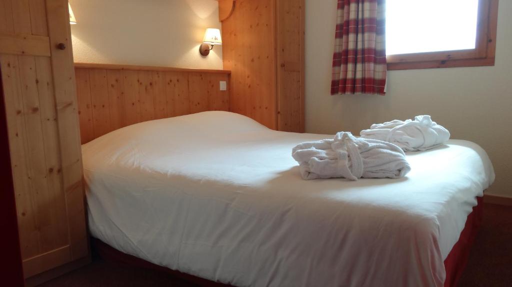 a bedroom with a bed with white towels on it at Les Alpages De Val Cenis by Resid&amp;co in Lanslebourg-Mont-Cenis