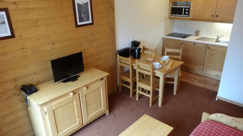 a small kitchen with a small table and a television at Les Alpages De Val Cenis by Resid&amp;co in Lanslebourg-Mont-Cenis