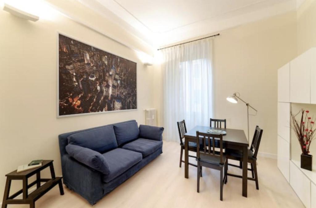 ローマにあるSunny flat in elegant building close to Colosseumのリビングルーム(青いソファ、テーブル付)