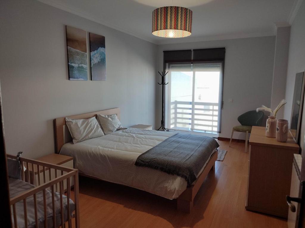 a bedroom with a large bed and a window at Big Wave House in Nazaré