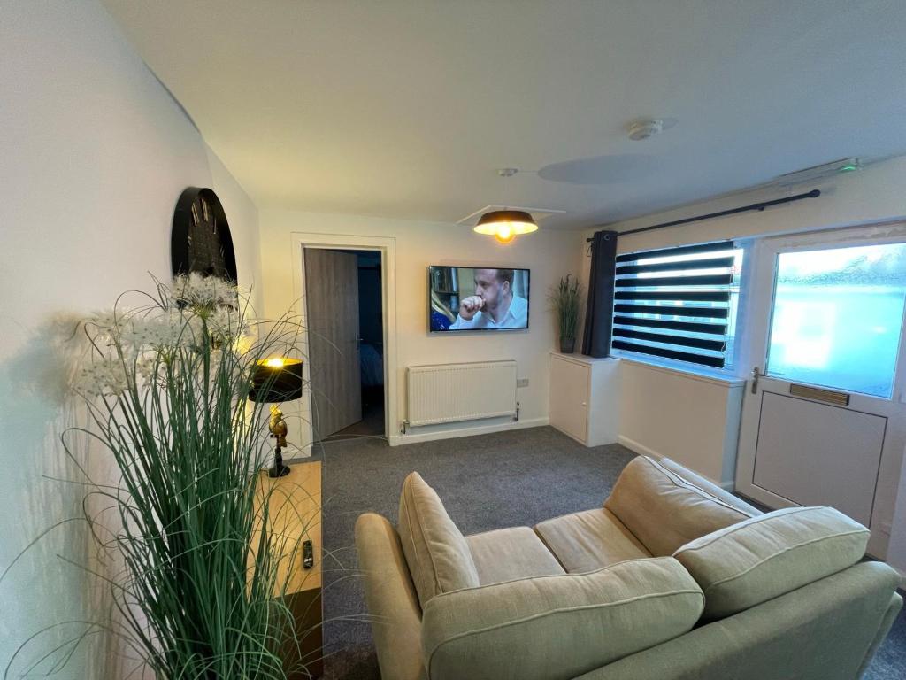 エルギンにあるServiced Accommodation Morayのリビングルーム(ソファ、壁掛けテレビ付)