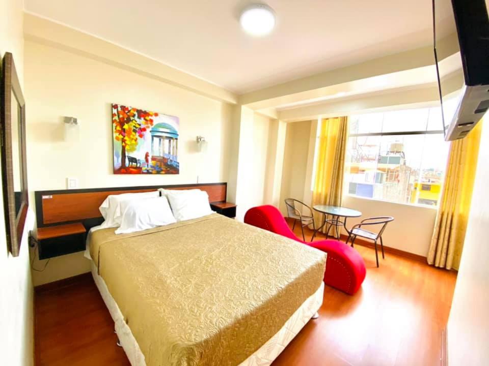 Habitación de hotel con cama, mesa y sillas en Hostal D' Rosas, en Tacna