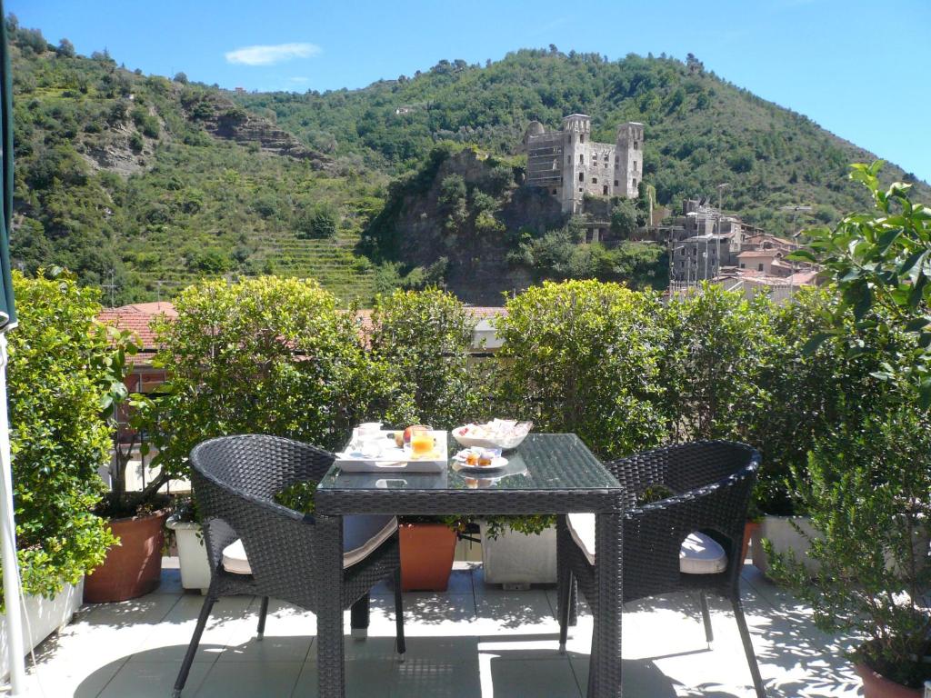 una mesa y sillas en un balcón con un castillo en B&B Dei Doria, en Dolceacqua