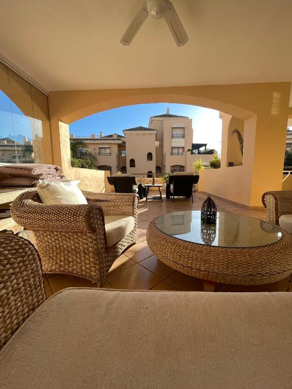 een woonkamer met rieten stoelen en een tafel bij Hacienda Elviria 2 Bedroom Spacious Apartment in Marbella