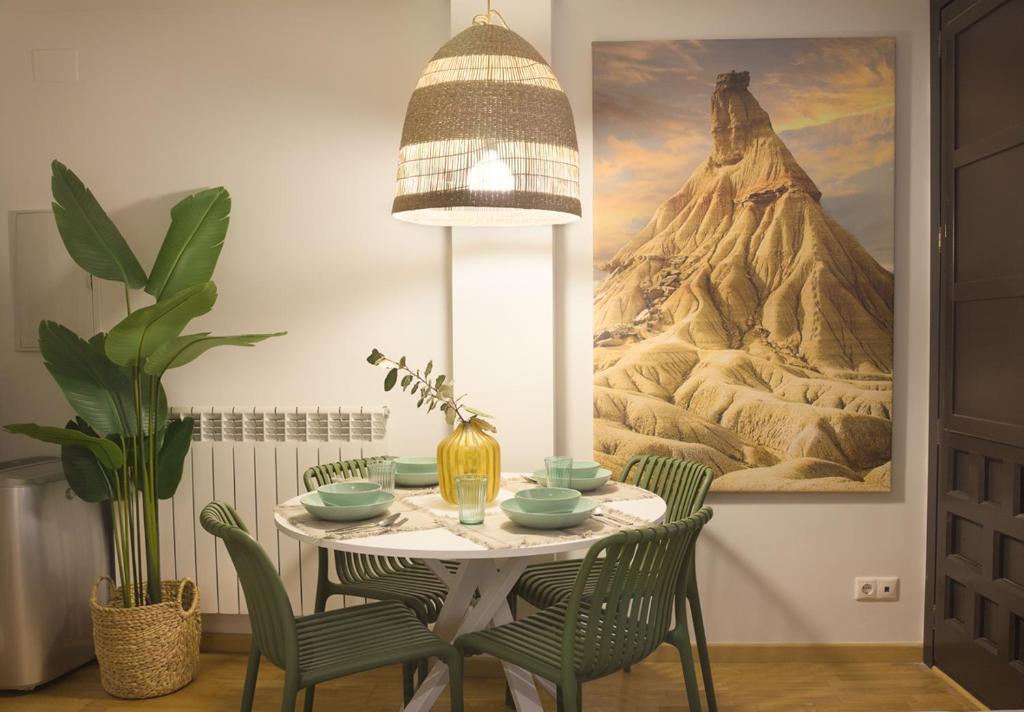 a dining room table with chairs and a painting on the wall at Apartamento Palacio Descalzos in Tudela