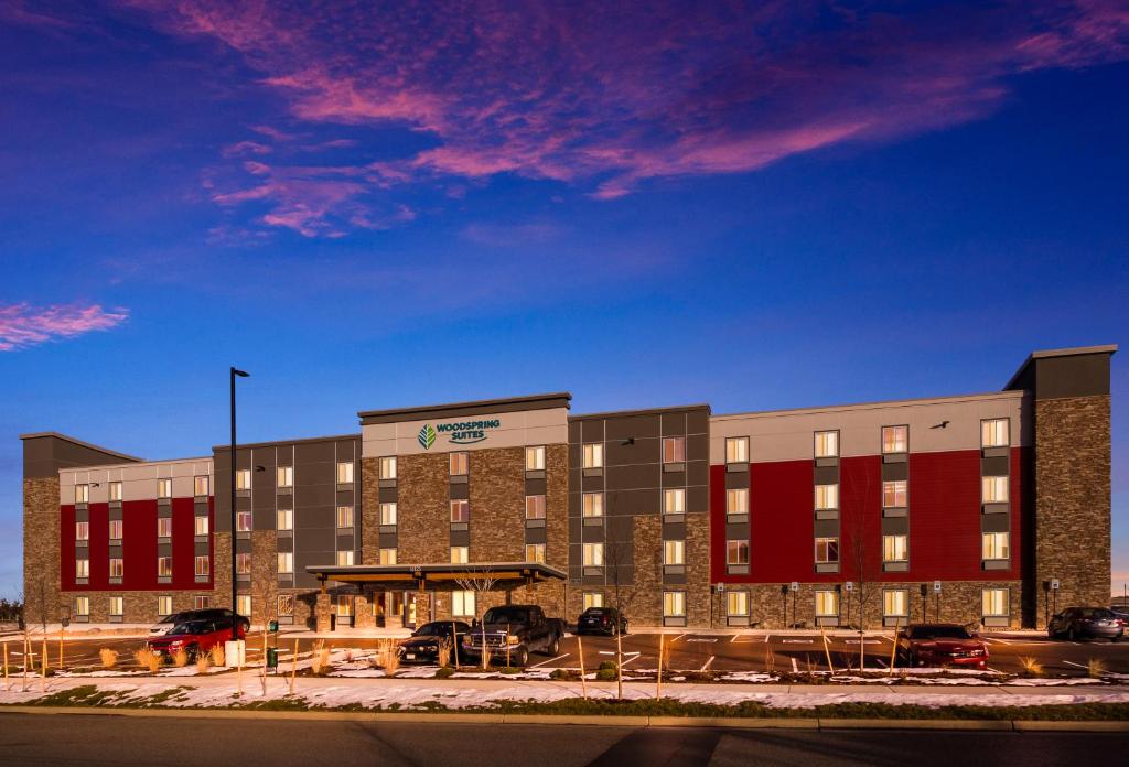 un hotel con coches estacionados en un estacionamiento en WoodSpring Suites Thornton-North Denver, en Thornton